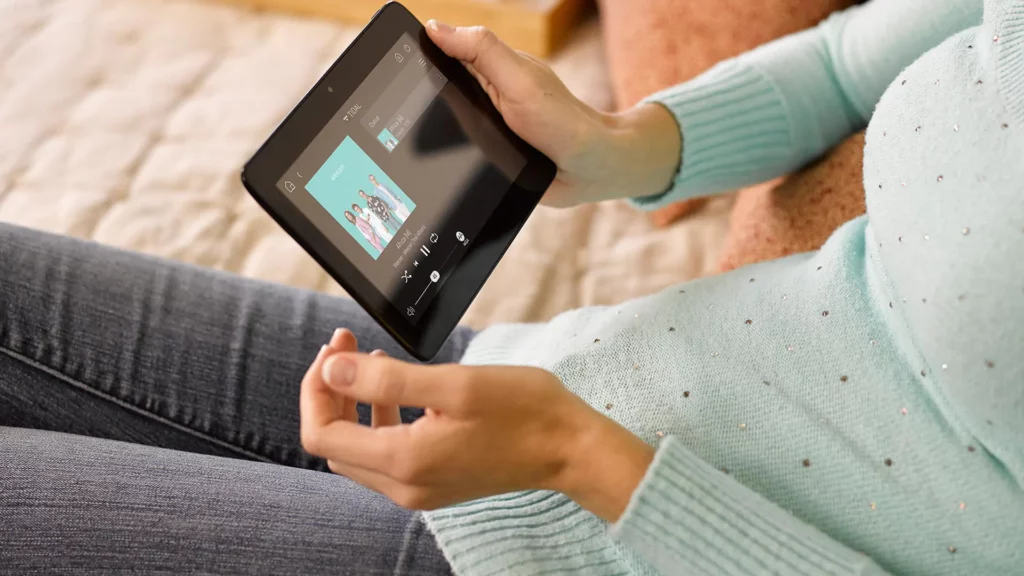 woman looking at tablet about to play a song on audio system